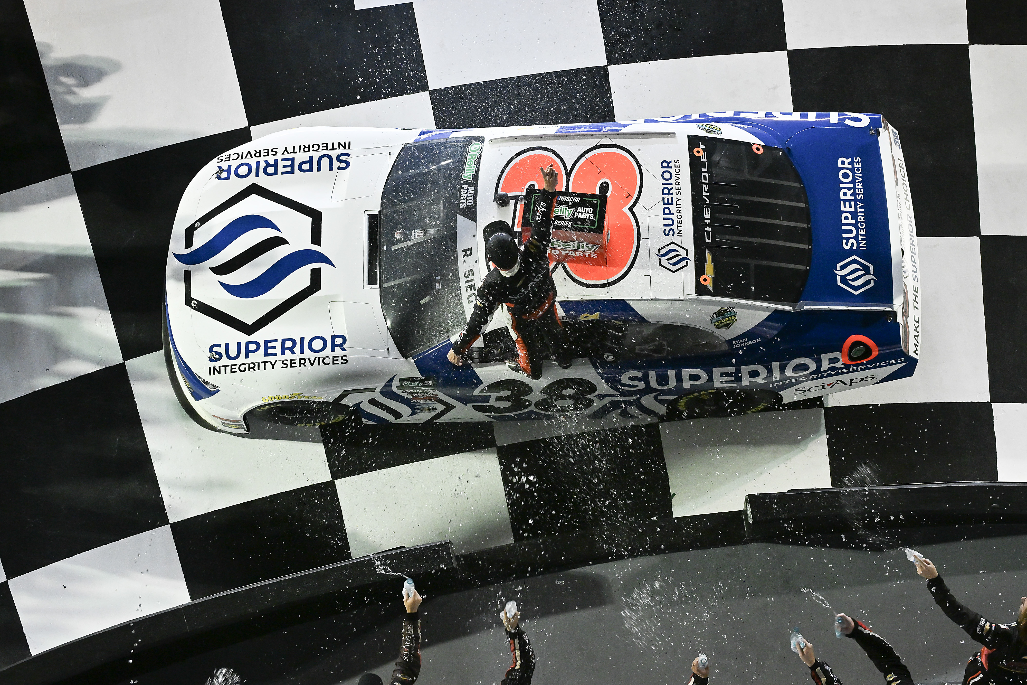 Ryan Sieg stands on the roof of the No. 38 on the checkered start-finish line as the celebration begins.